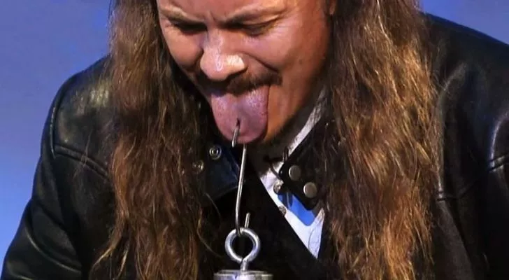 Thomas Blackthorne holding something heavy by his tongue