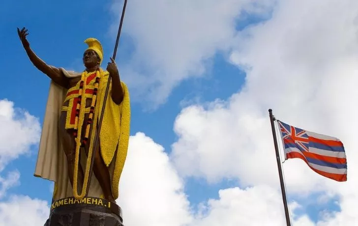A King Kamehameha I statue and the Hawaiian flag