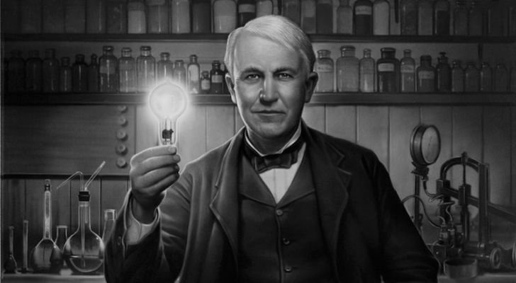 Thomas Edison holding a lit bulb