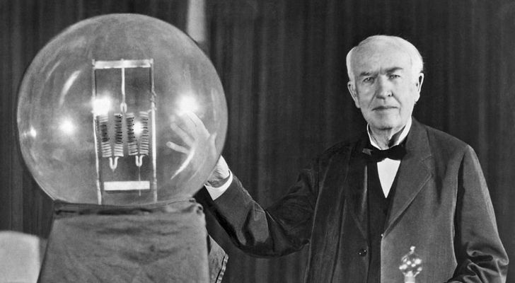 Thomas Edison next to a big bulb