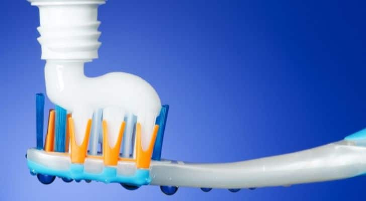 Toothpaste being squeezed onto a toothbrush