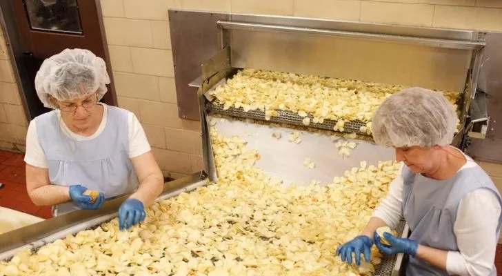 People working on the factory line at a potato chip factory