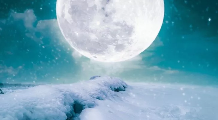 Full Cold Moon above a snowy landscape
