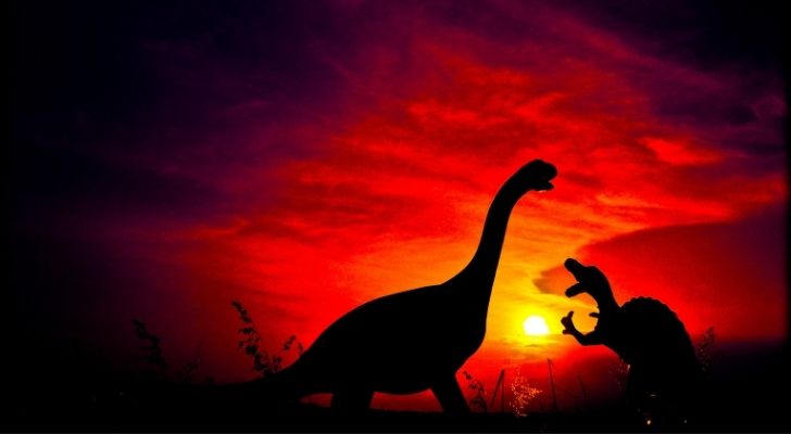 Dinosaurs with a deep red sky behind them