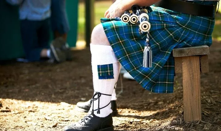 Someone wearing a blue/green kilt