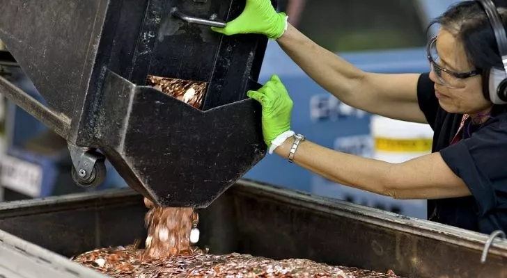 Pennies pouring down in a big container