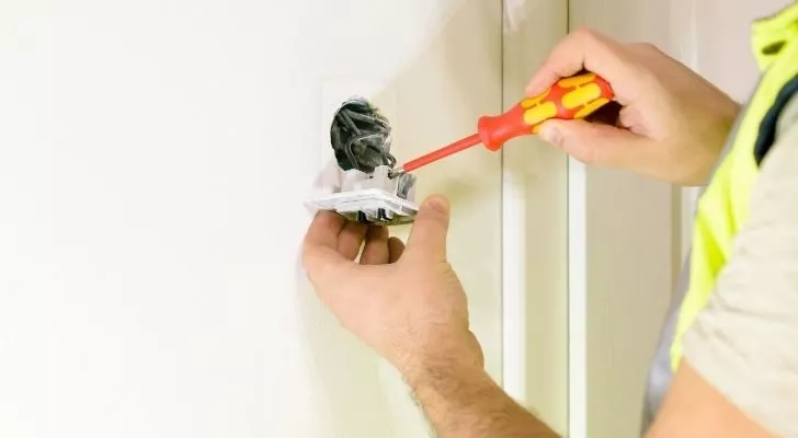 A person fixing the electricity switch.