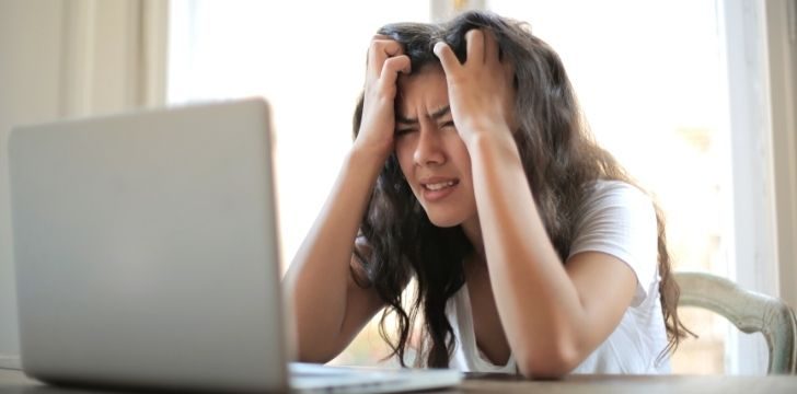 Una mujer frustrada con su computadora portátil
