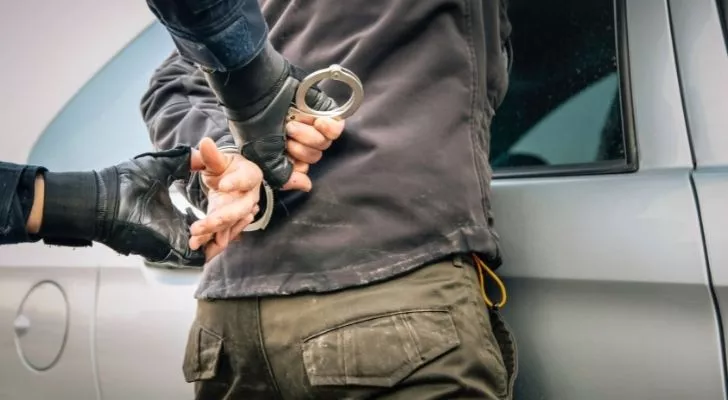 A person getting hand-cuffed.