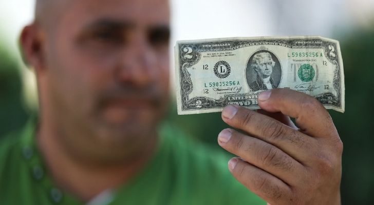 Person holding a $2 bill