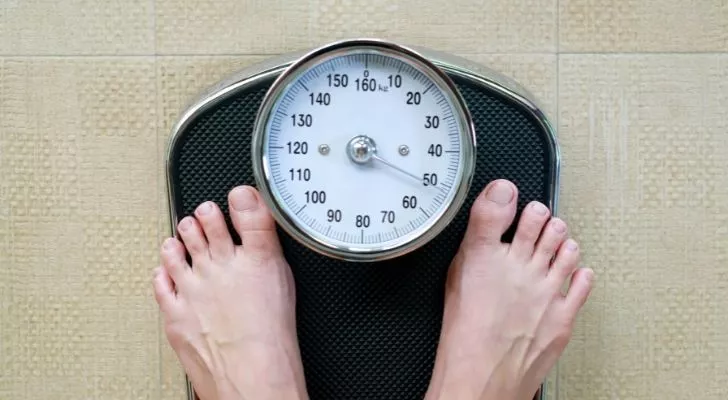 Person standing on a weighing scale.