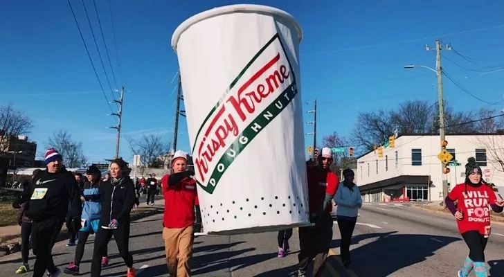 Krispy Kreme Challenge participants carrying a huge cup.