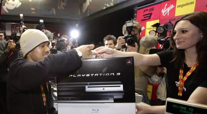 A man getting photographed while getting his PS3.