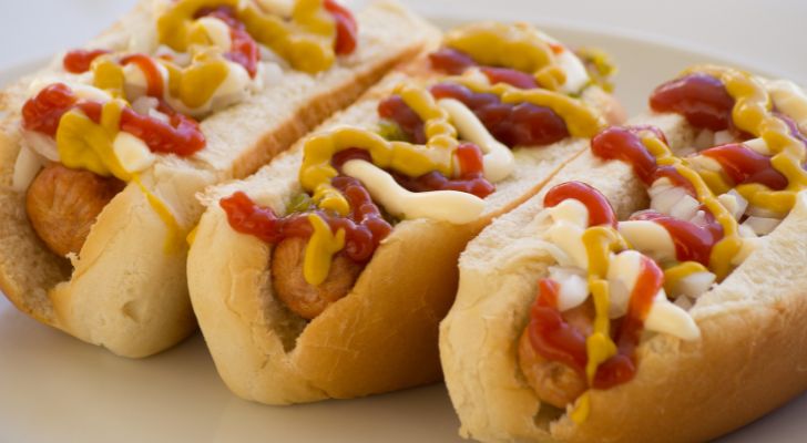 Three hotdog sandwiches with ketchup, mustard and mayonnaise.