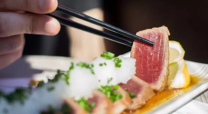 Someone eating sushi with chopsticks