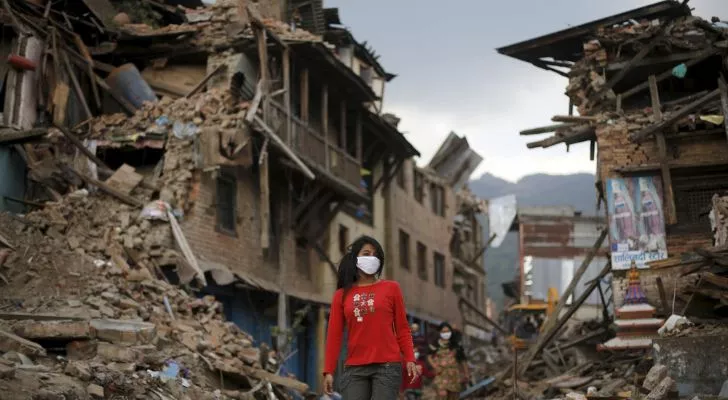 A woman walking through the rumble from an earthquake