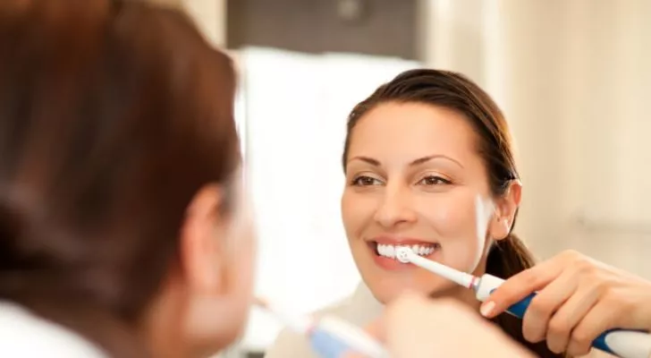 A woman using an electric toothbrush