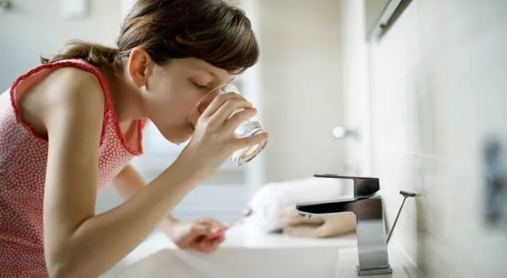 A girl swilling her mouth after brushing her teeth