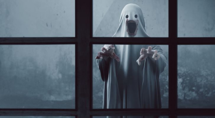 A scary looking ghost looking through the window