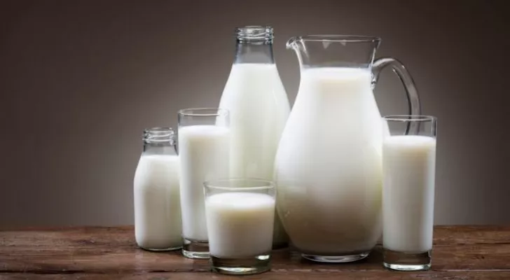 Different glasses and jugs filled with milk