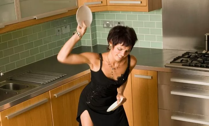 A person throwing plates on the floor.