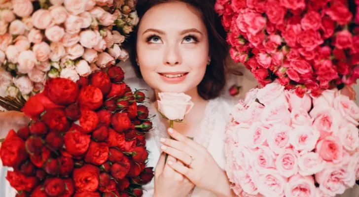 Someone smiling and surrounded by roses