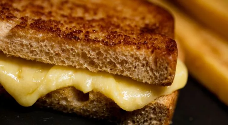 Cheese oozing out the side of a grilled cheese sandwich