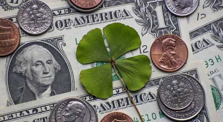 A four-leaf clover on a pile of money