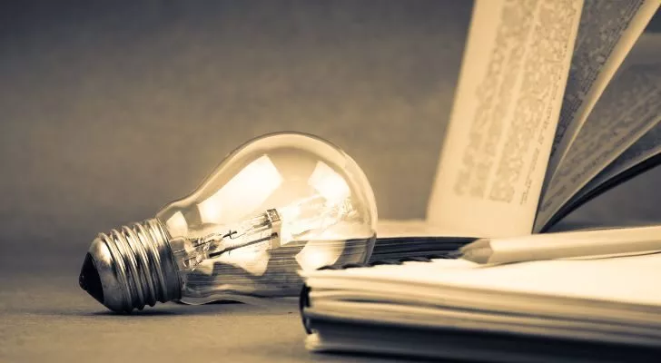 A light bulb and an open notebook, representing knowledge