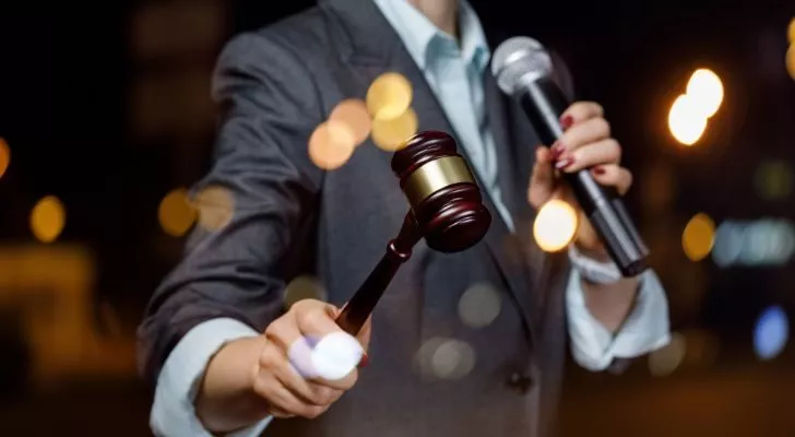An auctioneer holding a microphone and a gavel
