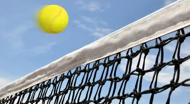 A tennis ball flying over a tennis net