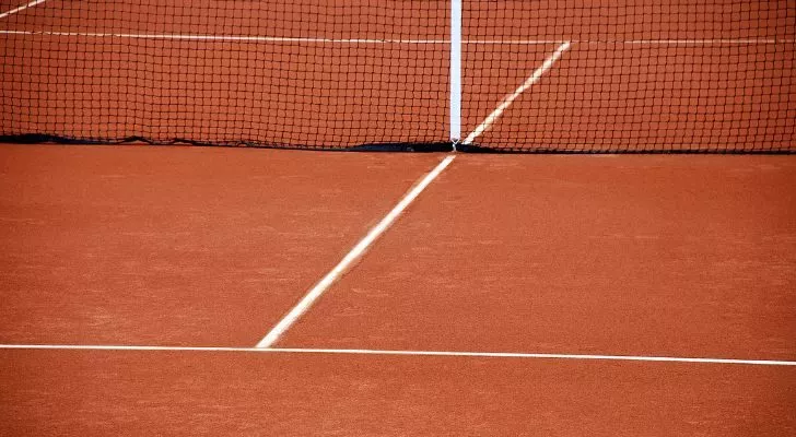A tennis net on a clay tennis court