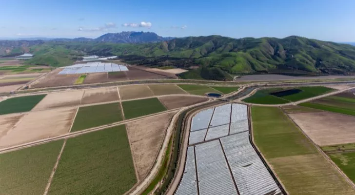 An agricultural area of California, with fields in the foreground and mountains in the background.
