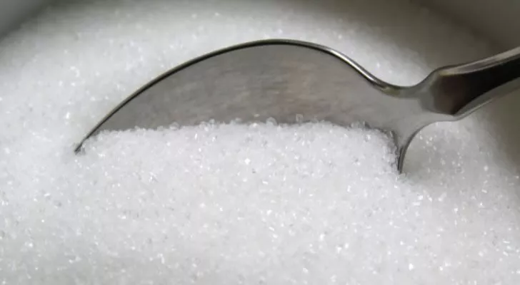 sugar, with a metal spoon in it