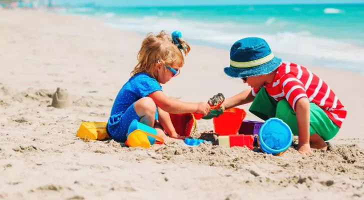Two children building sandcastles on a beach
