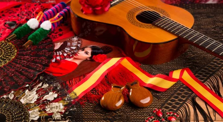 A guitar lying amongst some Spanish themed items