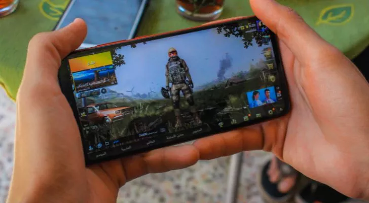 Someone holding a mobile phone in their hands playing a video game