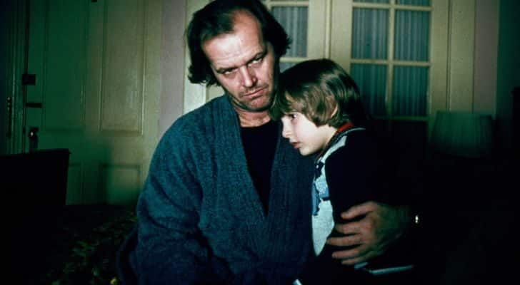 A man and a boy hug each other in the shadows