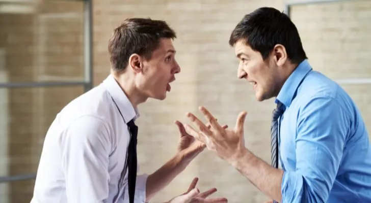 Two men in shirts and ties arguing
