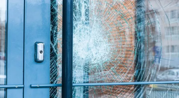 A door with a large pane of shattered glass