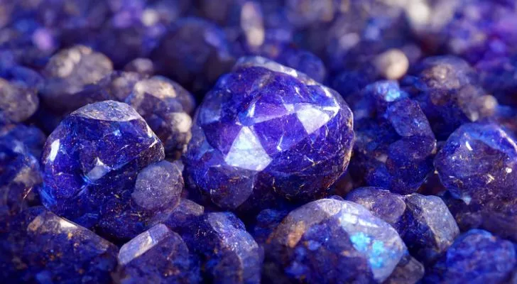 A collection of deep blue Tanzanite gemstones reflecting the light