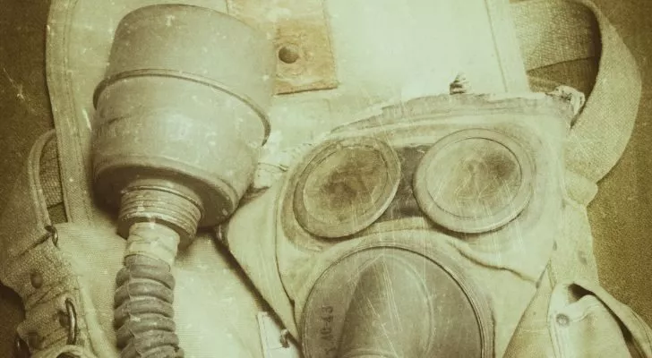 An old and battered gas mask sits on a table