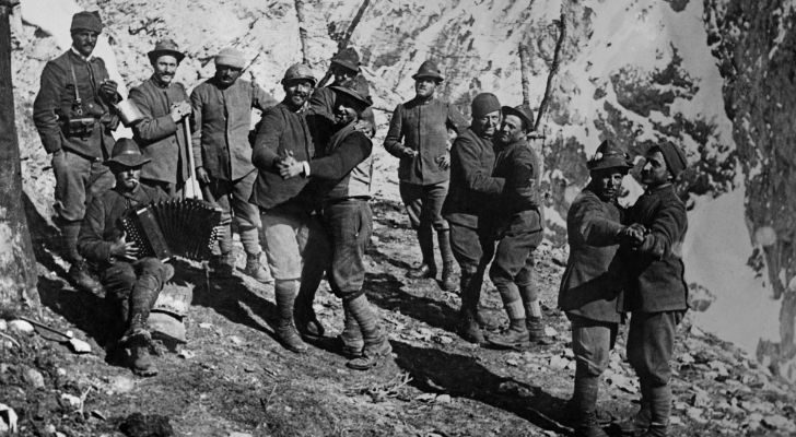 Soldiers dance together as another plays the accordion