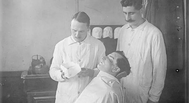 A plastic surgeon from WWI works on a patient's face
