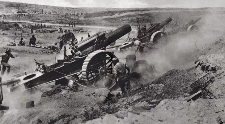 Several huge pieces of artillery fire into the distance