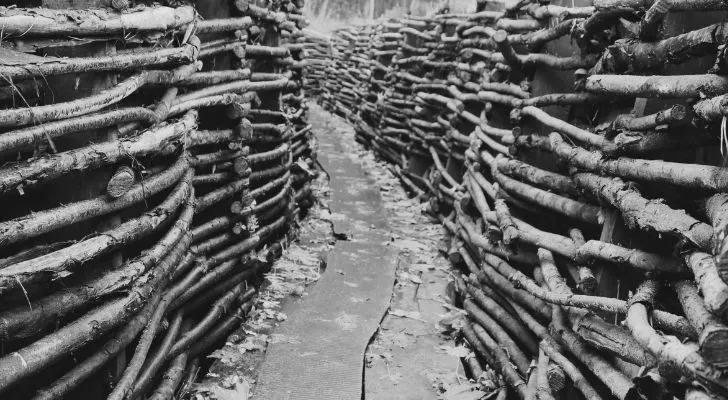 A trench held up with wooden sticks stretches out ahead