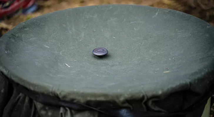 A beigoma spinning top spins in a bowl made of fabric