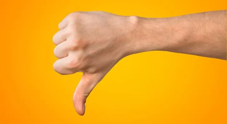 A hand showing negativity with the thumbs down gesture