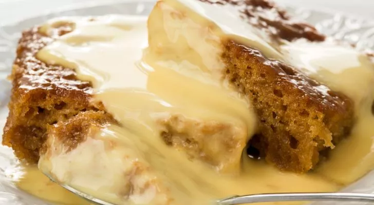 A sweet looking cake is served with custard