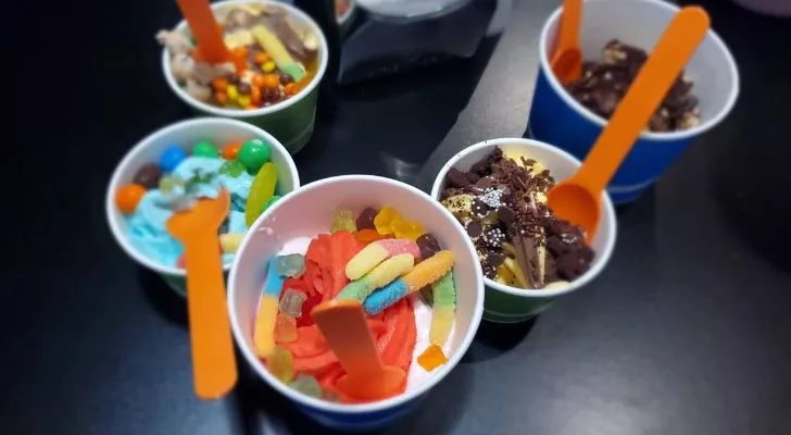 A selection of frozen yogurts with various candy toppings